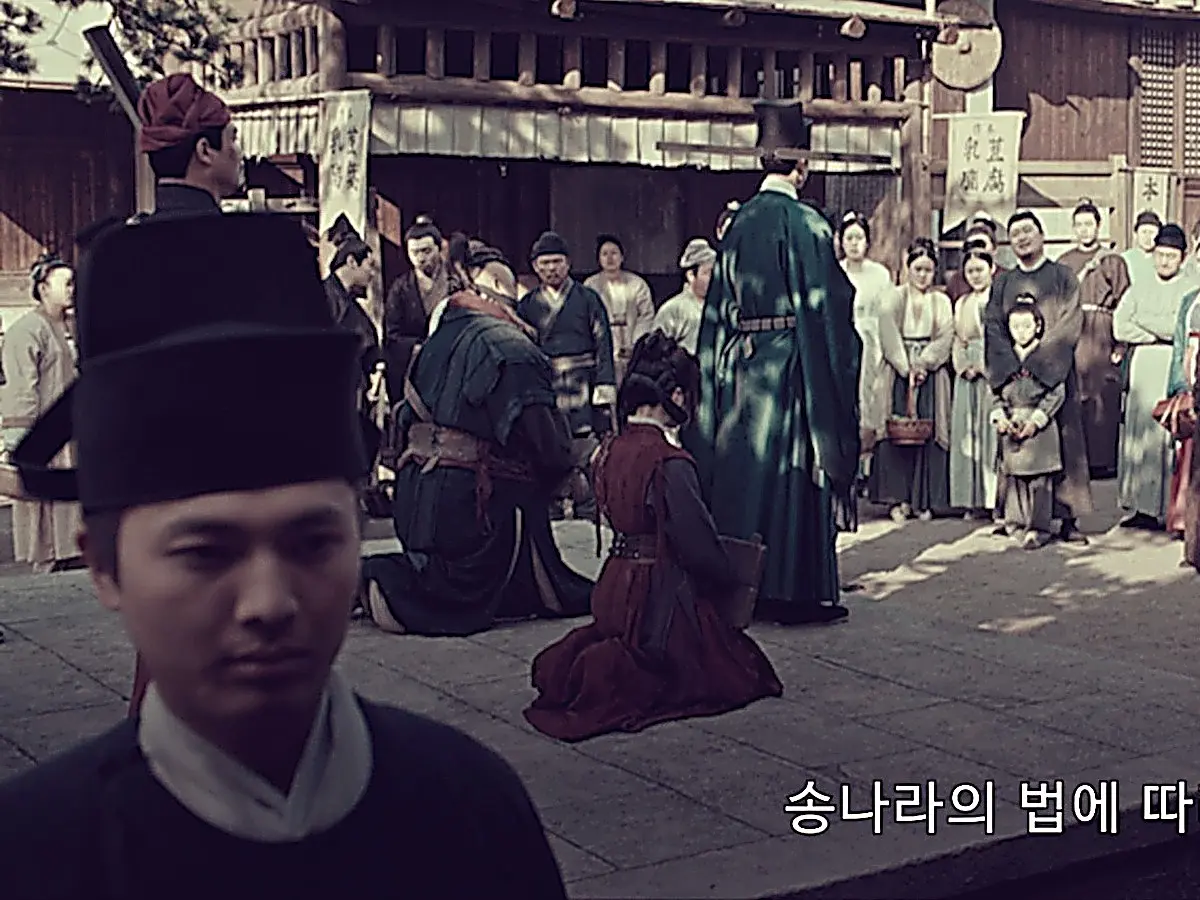 Hu Xiaotian conducting a public execution wearing a green Song Dynasty magistrate robe
