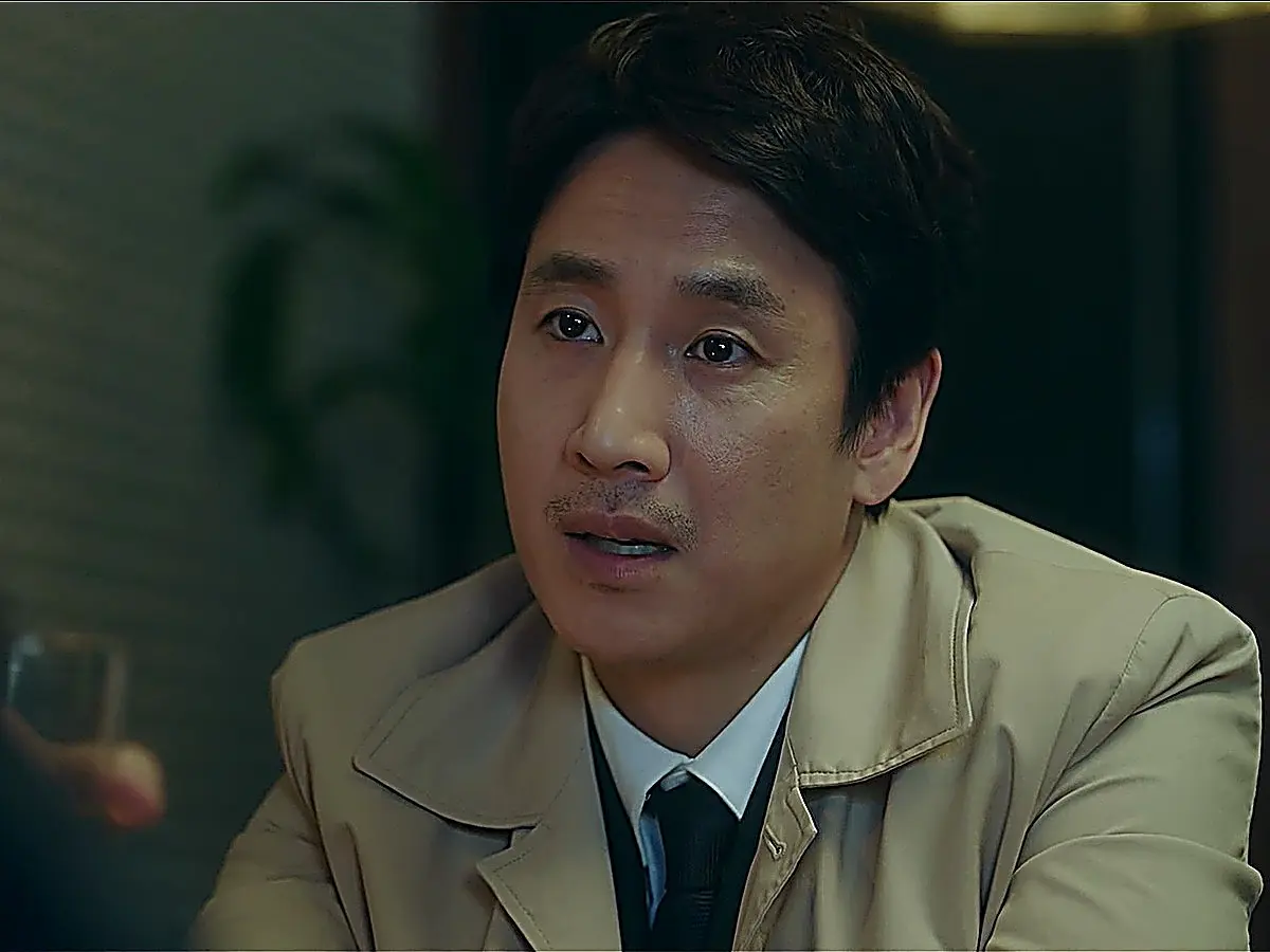 Park Dong-hoon wearing a beige trench coat over a collared shirt
