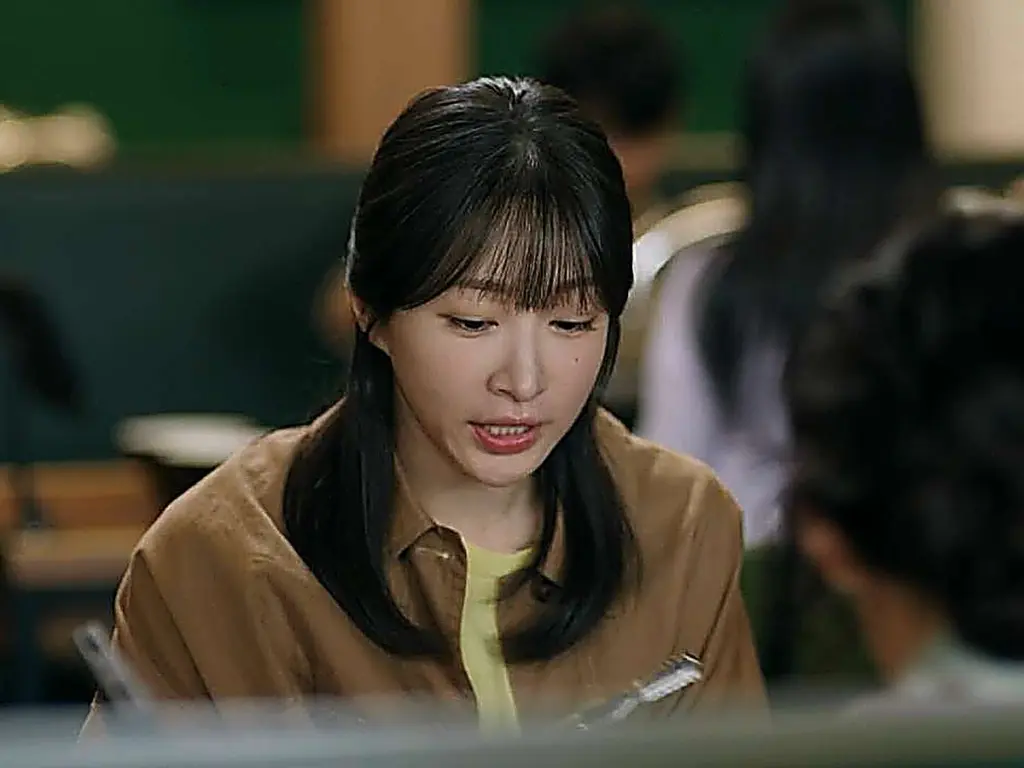 Han Gyu-rim wearing an open tan collared button-down shirt layered over a yellow crewneck top