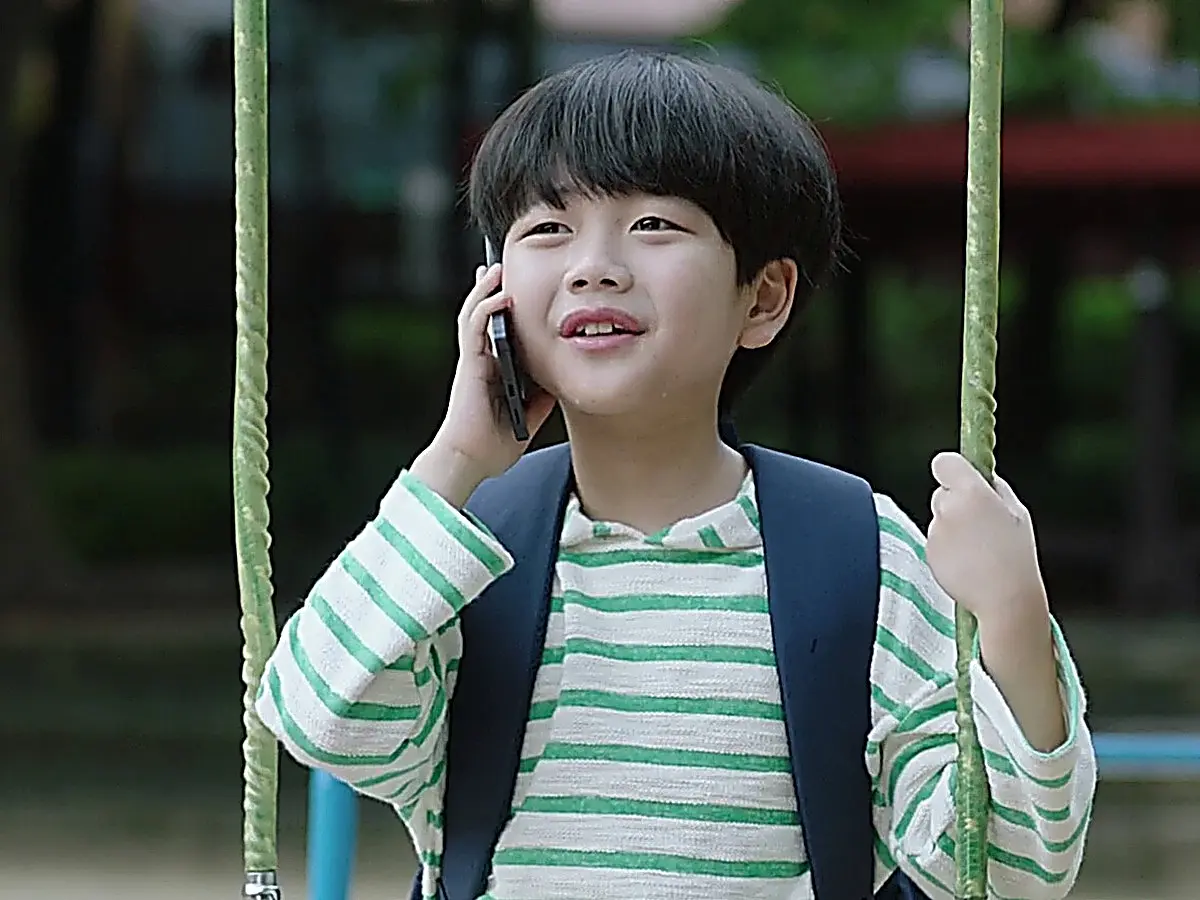 Han-gyeol crying on the swing during a phone call