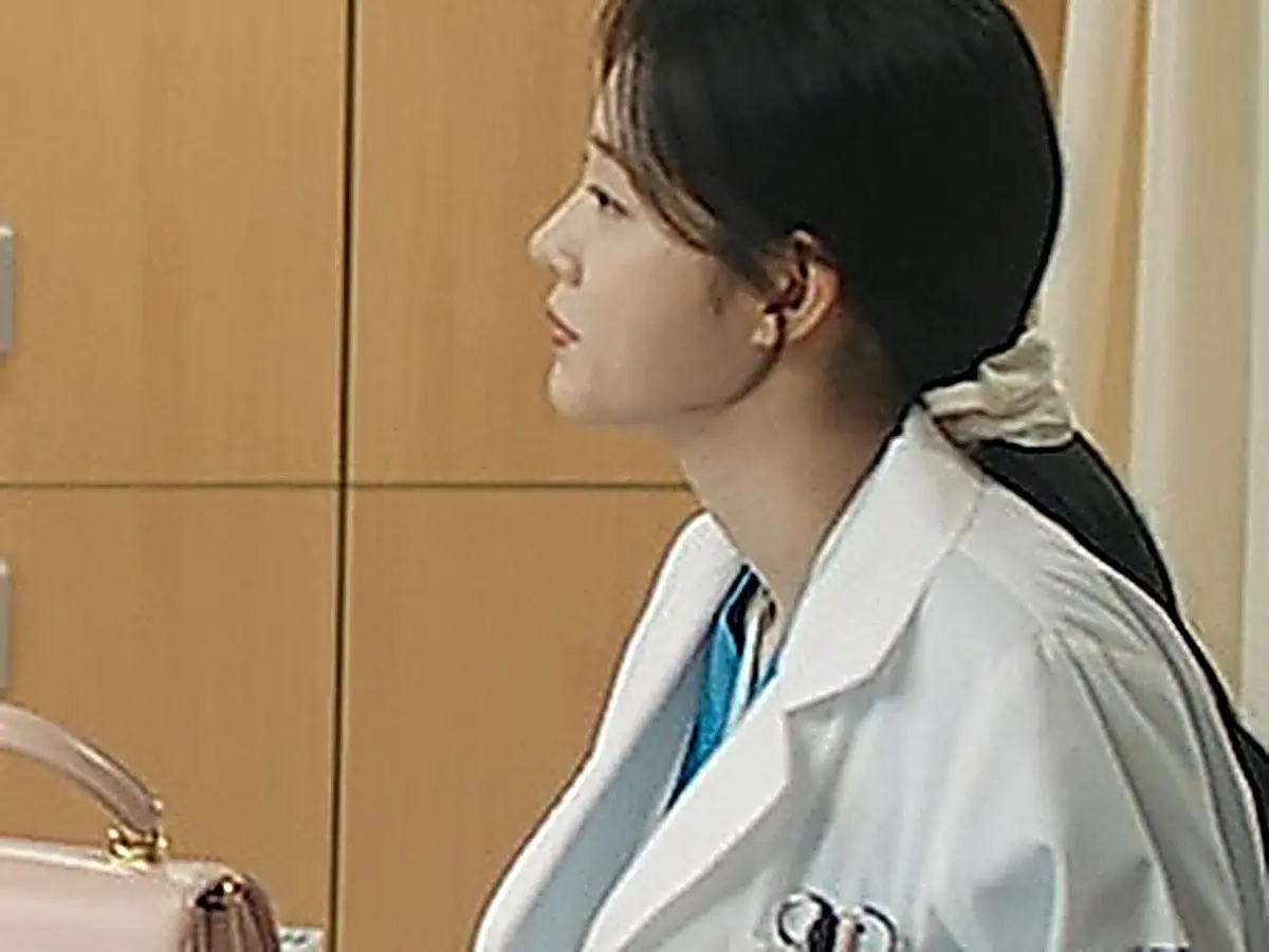 Hospital residents gathered around the medical office table in coats and scrubs
