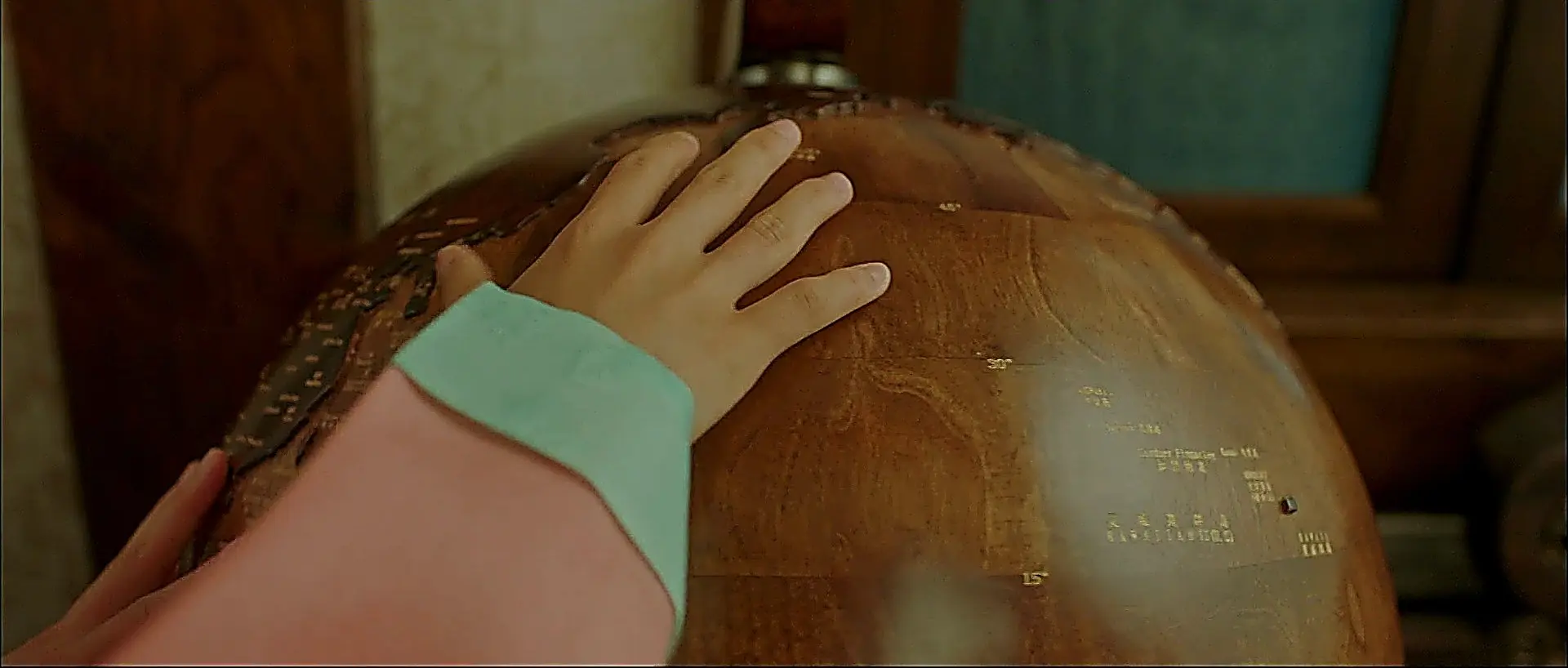 Go Ae-sin tracing the distance between nations on a wooden globe