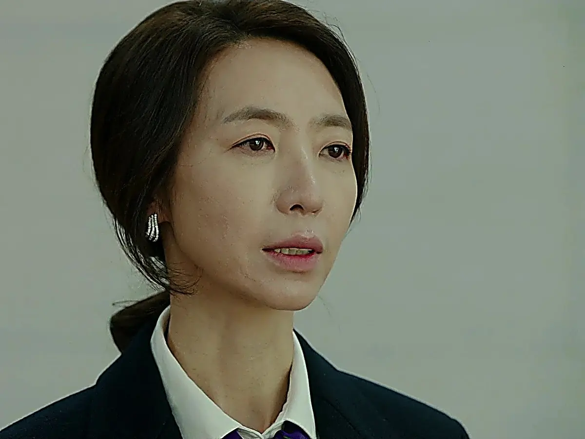 Han Jeong-yeon wearing a structured dark blazer over a collared white shirt