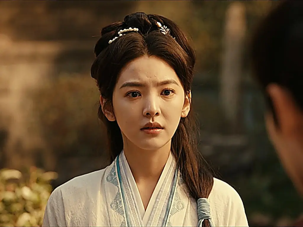 Guo Yinglong dressed in an off-white crossover robe with subtle blue patterned trim, wearing a pearl floral hair clip in her high updo